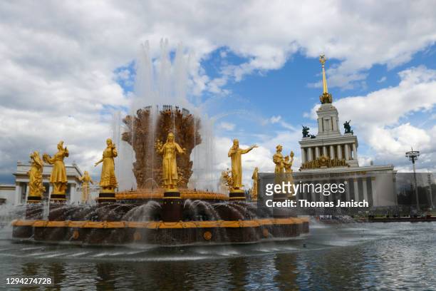 looking at the central pavilion and the friendship of nations fountain of the vdnkh, with dark clouds approaching - friendship of nations fountain fotografías e imágenes de stock