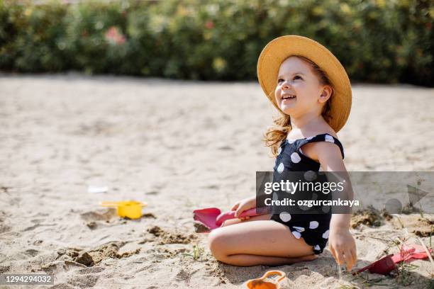 glücklich llittle mädchen spaßig auf sand - kids pool games stock-fotos und bilder