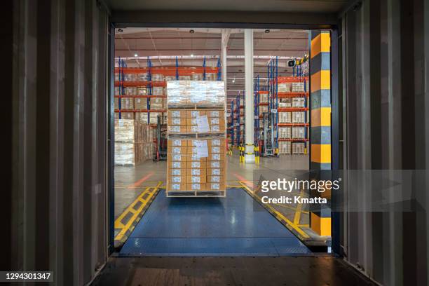 workers loading truck with forklift. - offloading stock-fotos und bilder