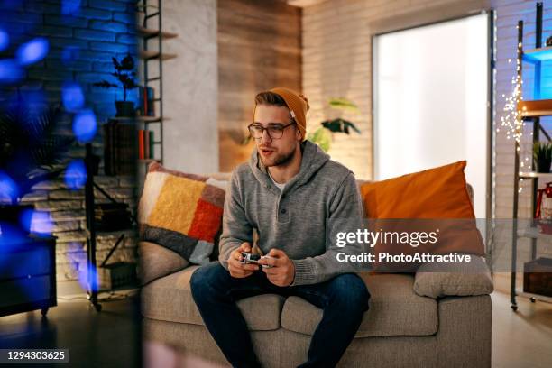 online gaming concept. guy playing football video game with joystick - betting stock pictures, royalty-free photos & images