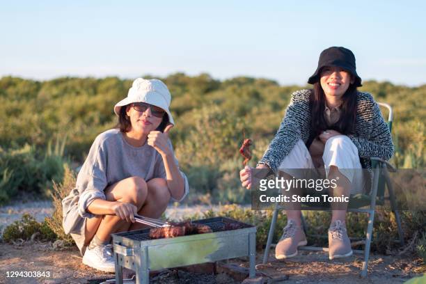 frauen, die grillen auf einem picknick im freien nahaufnahme - emirati lady from back stock-fotos und bilder