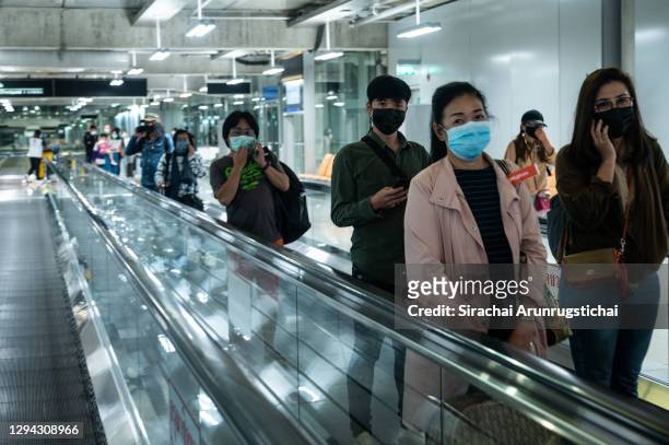 Arriving passengers ride the moving walkway after taking domestic flight to Suvarnabhumi International Airport , one of the largest airports in...