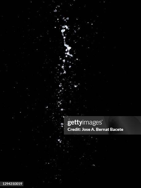 full frame of the textures formed  by the water jets to pressure with drops floating in the air of white color on a black background - water sprayer stock pictures, royalty-free photos & images