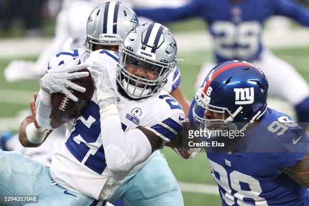 Ezekiel Elliott of the Dallas Cowboys runs the ball against Austin Johnson of the New York Giants during the second quarter at MetLife Stadium on...
