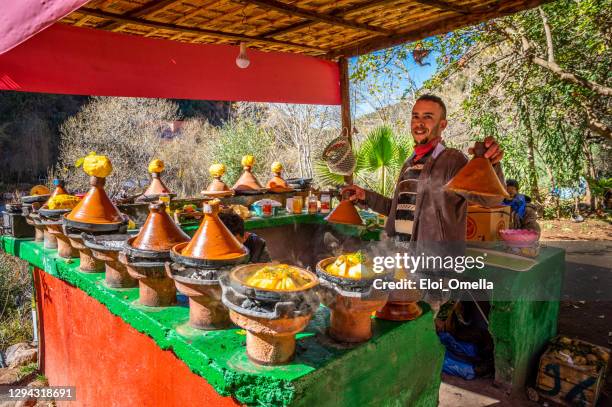 giovane venditore che cucina tajine di pollo nella valle di ourika, marocco - north africa foto e immagini stock