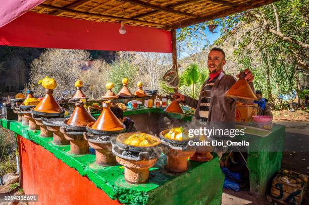 young seller cooking chicken tajines in ourika valley, morocco - tajine stock pictures, royalty-free photos & images