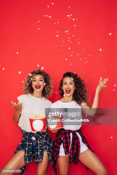 photo of two beautiful girls posing with a popcorn buckets - model eating stock pictures, royalty-free photos & images