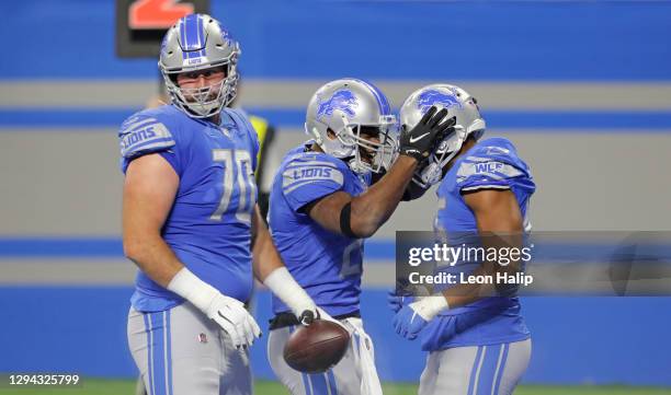 Adrian Peterson of the Detroit Lions celebrates with teammates Jason Cabinda and Dan Skipper after scoring a touchdown during the third quarter of...