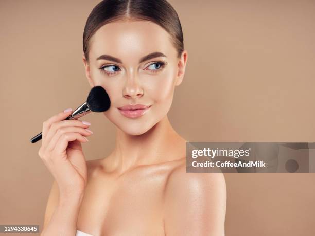 schöne junge frau, die foundation powder aufträgt - rouge stock-fotos und bilder