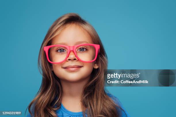 funny little girl wearing glasses on a colored background - sweet little models stock pictures, royalty-free photos & images