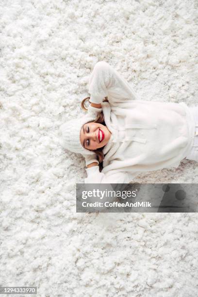 fille se couchant sur la neige - cardigan photos et images de collection