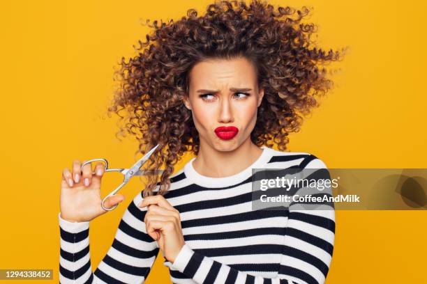 close-up photo of a beautiful girl holds hair scissors and ready to change her hairstyle - bad hairdresser stock pictures, royalty-free photos & images