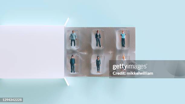 concept of self isolation with people behind plastic in blister pack - blister package stock pictures, royalty-free photos & images