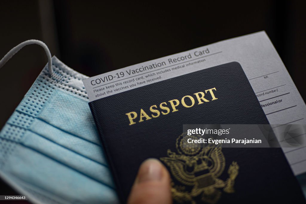 COVID-19 Vaccination Record card, Passport of USA and Medical Mask. Immune passport or certificate for travel concept.