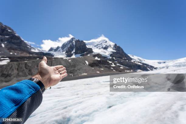 human hand pointing columbia icefield in jasper national park, canada - columbia icefield stock pictures, royalty-free photos & images