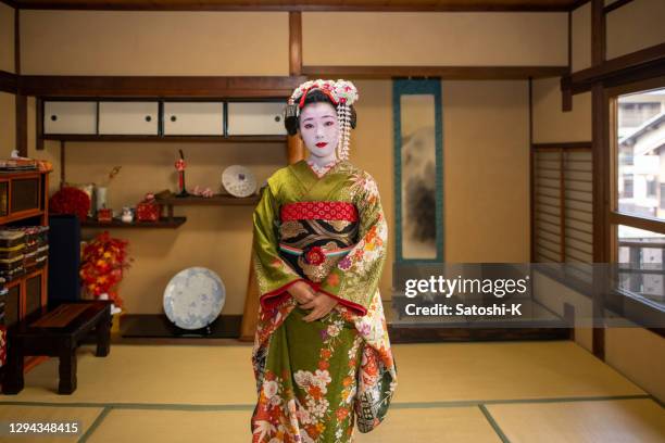 portrait of maiko (geisha in training) standing in japanese tatami room - geisha in training stock pictures, royalty-free photos & images