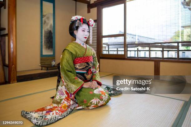maiko (geisha in training) sitting on heels and greeting customers in japanese tatami room - geisha in training stock pictures, royalty-free photos & images