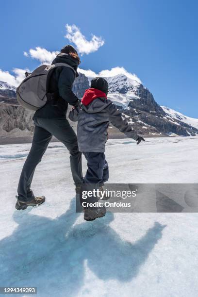 mother and son hiking columbia icefield, jasper national park, canada - columbia icefield stock pictures, royalty-free photos & images