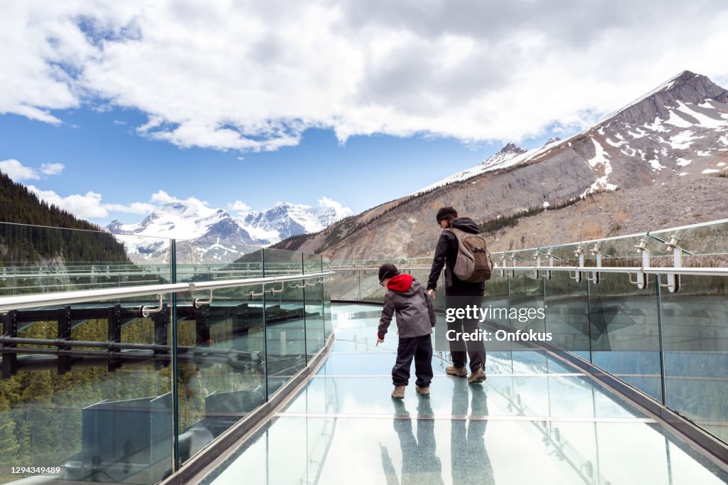 Mère et fils se réveillant sur la passerelle de champ de glace de Columbia pendant l’été dans le parc national de Jasper
