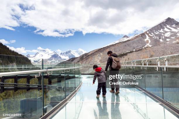 mère et fils se réveillant sur la passerelle de champ de glace de columbia pendant l’été dans le parc national de jasper - passerelle pont photos et images de collection