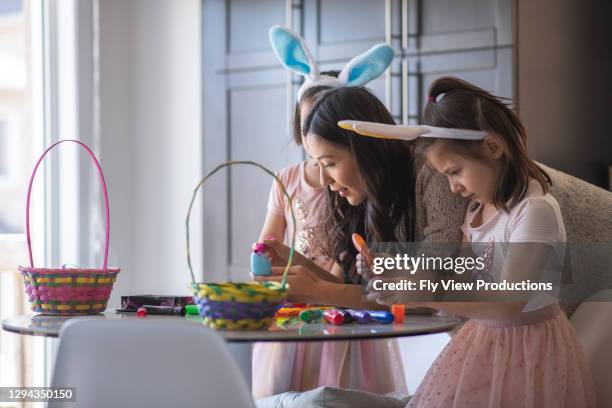 mom and daughters on easter - easter basket with candy stock pictures, royalty-free photos & images