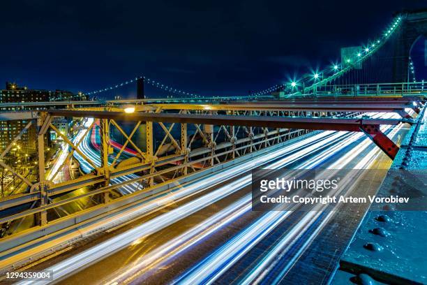 night traffic over the brooklyn bridge - brooklyn bridge photos et images de collection