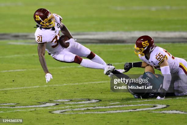 Strong safety Kamren Curl of the Washington Football Team is tackled by tight end Dallas Goedert of the Philadelphia Eagles after an interception...