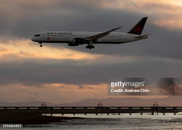Air Canada flight AC115 from Toronto lands at Vancouver International Airport as the sun sets on January 03, 2021 in Richmond, British Columbia,...