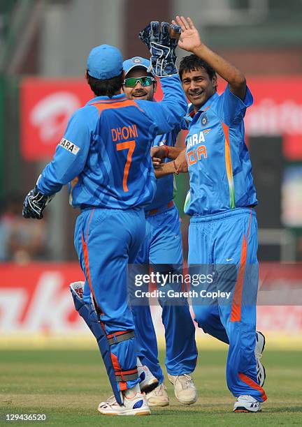 Praveen Kumar of India celebrates with captain MS Dhoni after dismissing England captain Alastair Cook during the 2nd One Day International between...