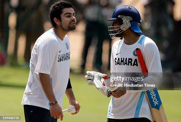 Indian cricketers Virat Kohli and Praveen Kumar having a chat during a practice session at Rajiv Gandhi Stadium on October 13, 2011 in Hyderabad,...