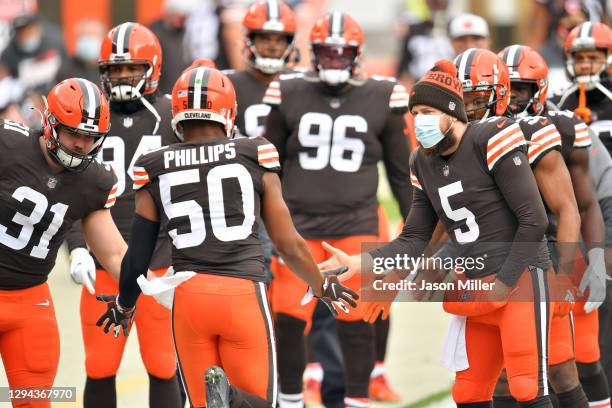 Quarterback Case Keenum celebrates with linebacker Jacob Phillips of the Cleveland Browns during player introductions prior to the game against the...