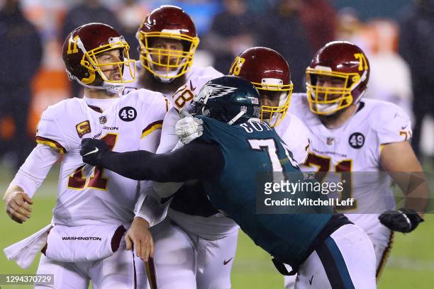 Quarterback Alex Smith of the Washington Football Team is pressured by defensive end Vinny Curry of the Philadelphia Eagles after a pass in the third...