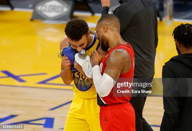 Stephen Curry of the Golden State Warriors is congratulated by Damian Lillard of the Portland Trail Blazers after Curry scored a career-high 62...