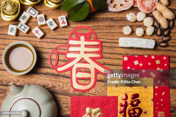 flat lay chinese new year traditional snacks with red envelops and mahjong tiles - tea cup overhead view photos et images de collection