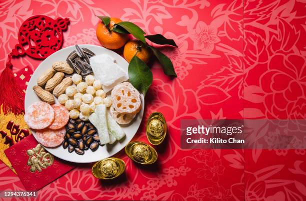 flat lay chinese new year traditional snacks with red envelops - chinese new year food stock pictures, royalty-free photos & images