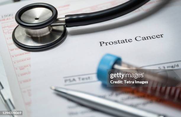 studio shot of prostate cancer document, stethoscope and blood sample - psa stockfoto's en -beelden