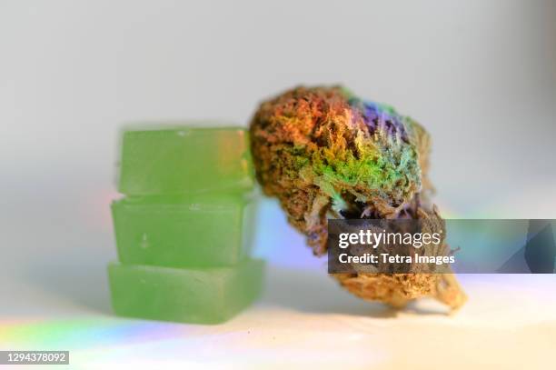 stack of edible cannabis gummies and cannabis bud - gummy snoep stockfoto's en -beelden