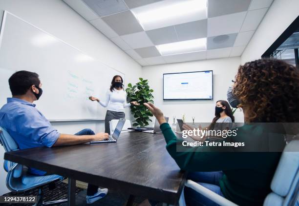 businesswoman in face mask giving presentation in office - infection prevention stockfoto's en -beelden