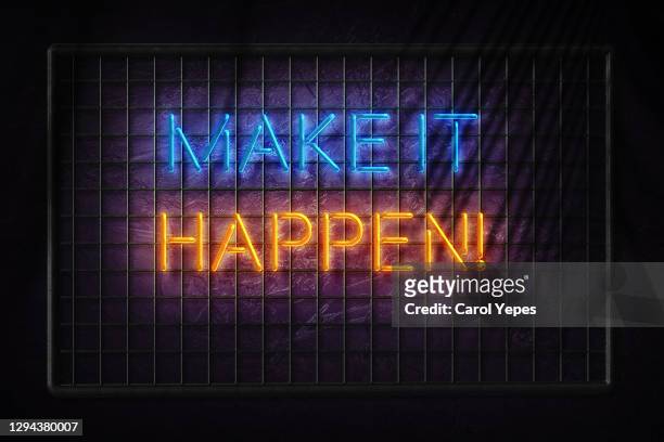 make it happen text in neon lights - montar fotografías e imágenes de stock