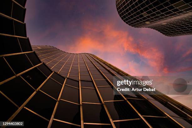 modern glass skyscrapers from directly below with stunning sunset sky. - diminishing perspective - fotografias e filmes do acervo