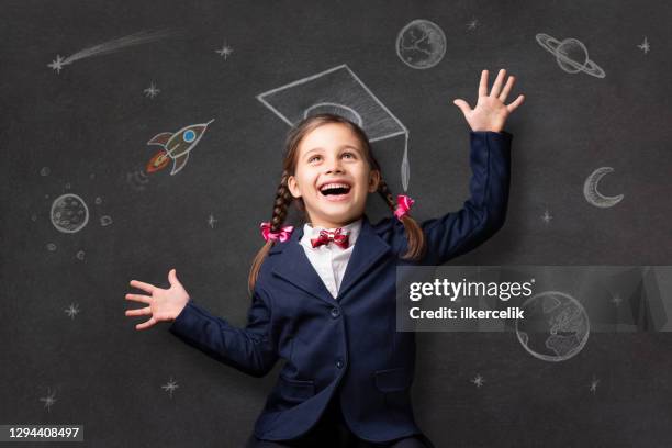 portrait of a child schoolgirl with imagination at the blackboard - adult imitation stock pictures, royalty-free photos & images