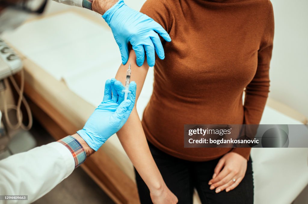 Close up of pregnant woman getting vaccinated