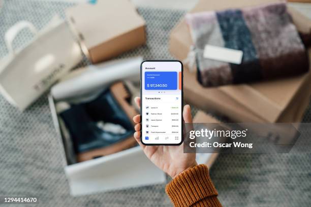 tracking bank account transactions with mobile banking - hand holding credit card stock pictures, royalty-free photos & images