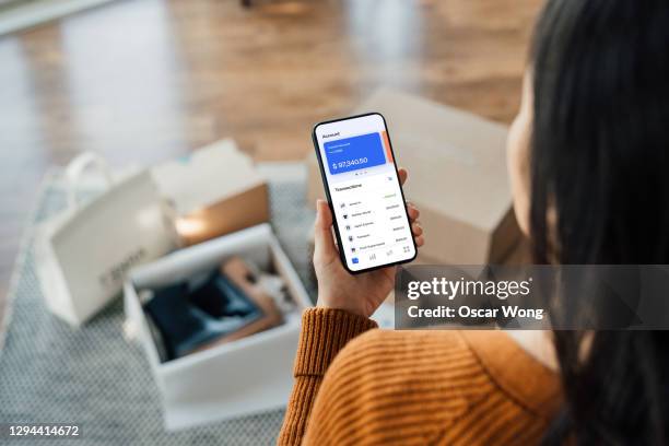 tracking bank account transactions with mobile banking - frau mit handy screen stock-fotos und bilder