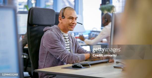 mature man working in call centre - hairless mouse stock pictures, royalty-free photos & images