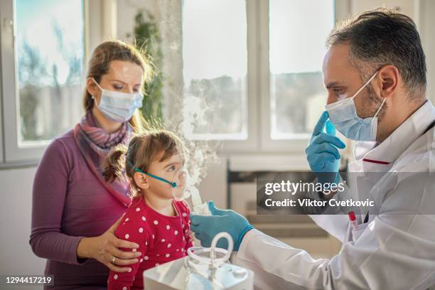 médico que aplica tratamiento de inhalación de medicamentos - nebulizador fotografías e imágenes de stock