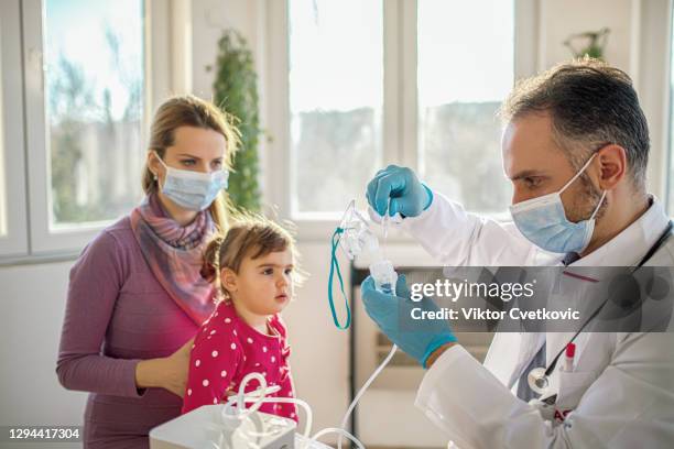 medical doctor applying medicine inhalation treatment - inhalation stock pictures, royalty-free photos & images