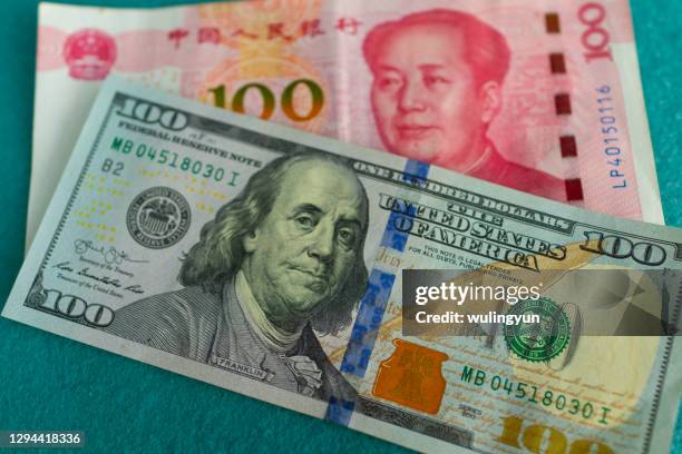 american 100 dollar bill with chinese 100 yuan bill - billete de yuan chino fotografías e imágenes de stock