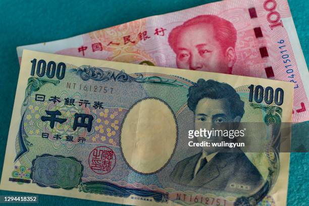 chinese 100 yuan bill with japanese 1000 yen bill - images of chinese yuan banknotes stock pictures, royalty-free photos & images
