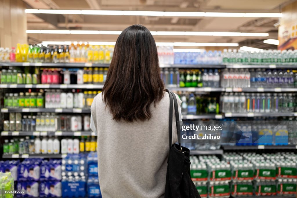 Back view of female millennial customers in supermarket